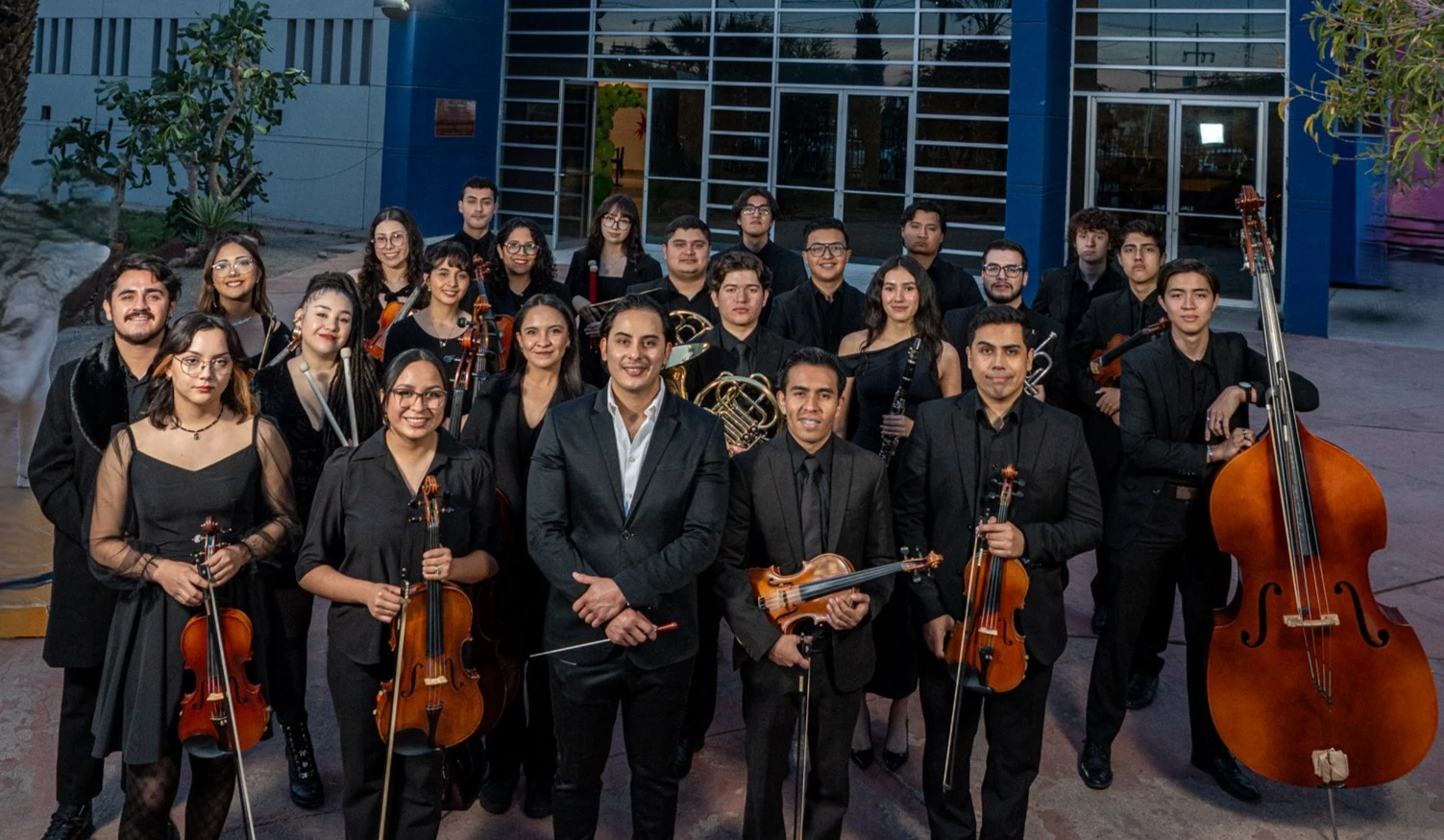 Equipo de orquesta filarmónica formado por músicos profesionales en sesión institucional
